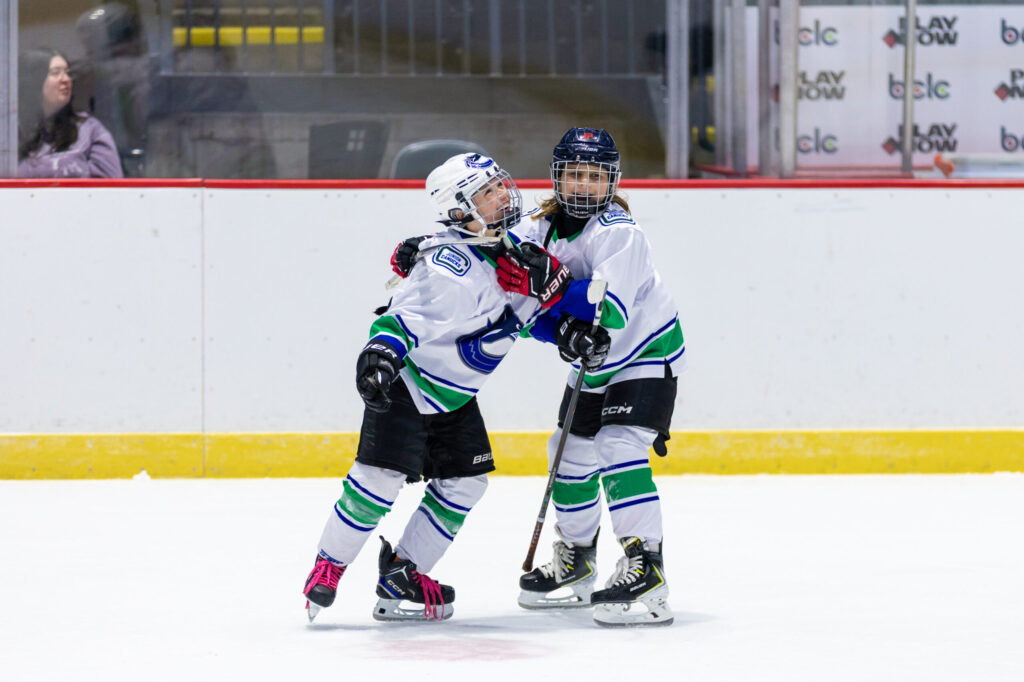Two kids celebrating on ice